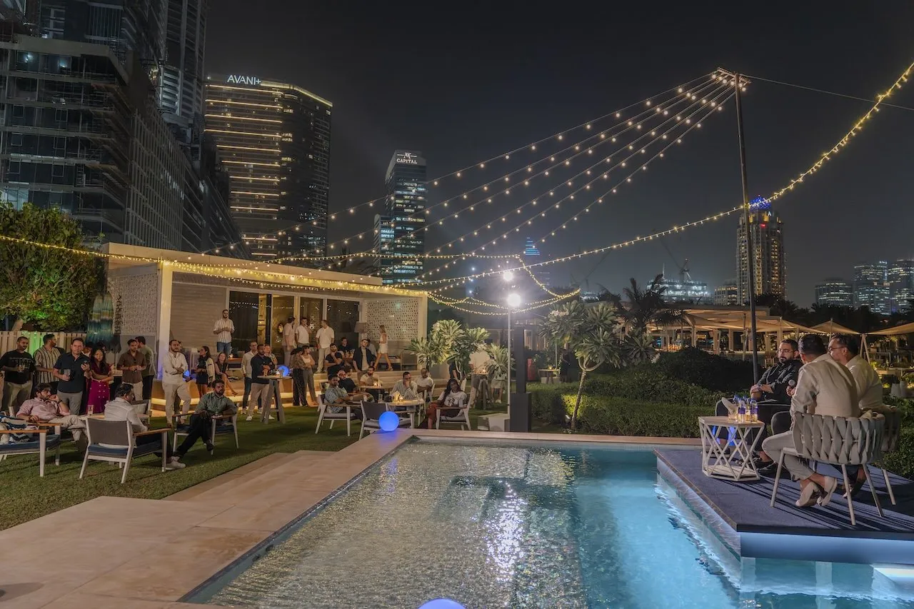 Wide view of the panel by the pool with guests seated on the lawn